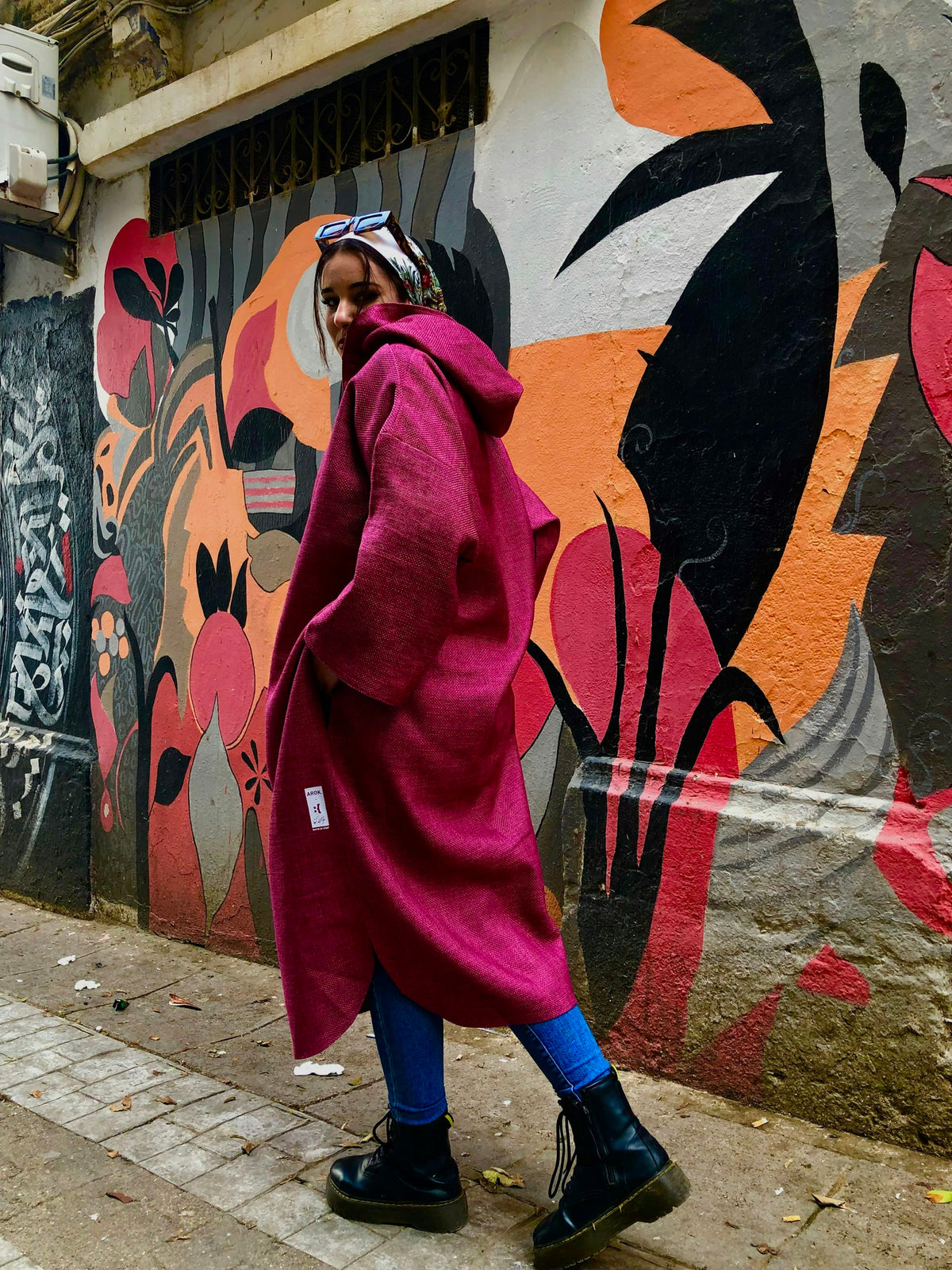 Femme élégante en manteau rose dans la rue